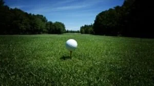 Una pelota de golf se asienta sobre un tee en un campo de hierba.